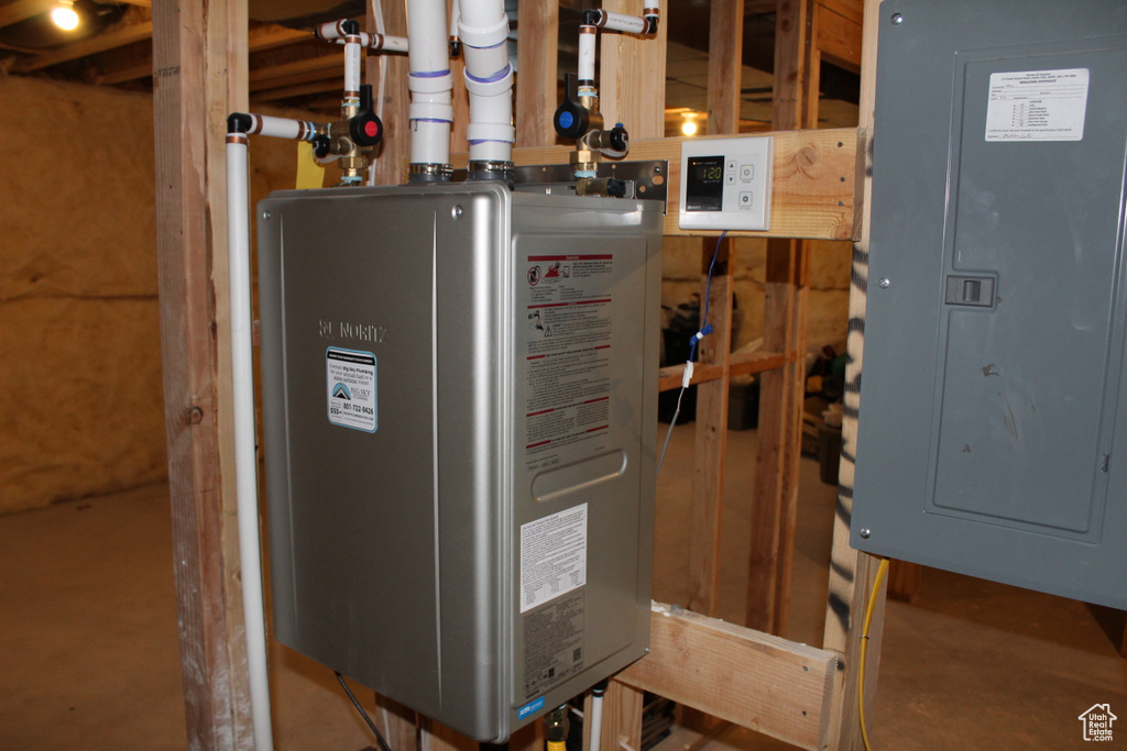 Utility room featuring electric panel and water heater