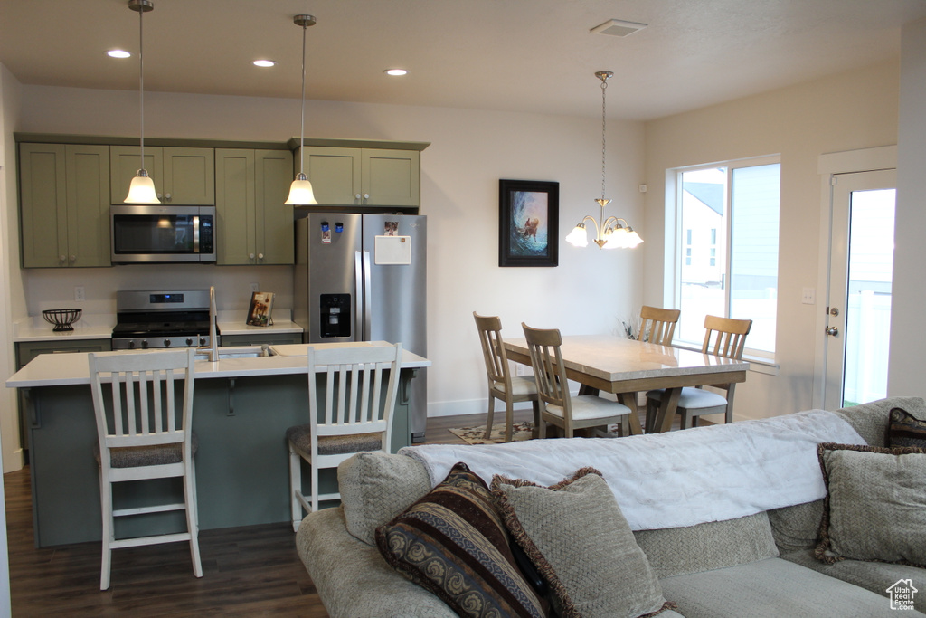 Living room featuring dark wood-type flooring, recessed lighting, a chandelier, and baseboards