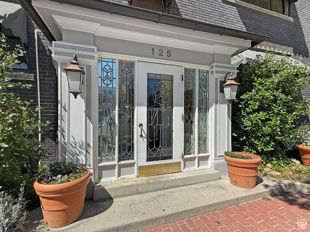 Entrance to property with brick siding and mansard roof