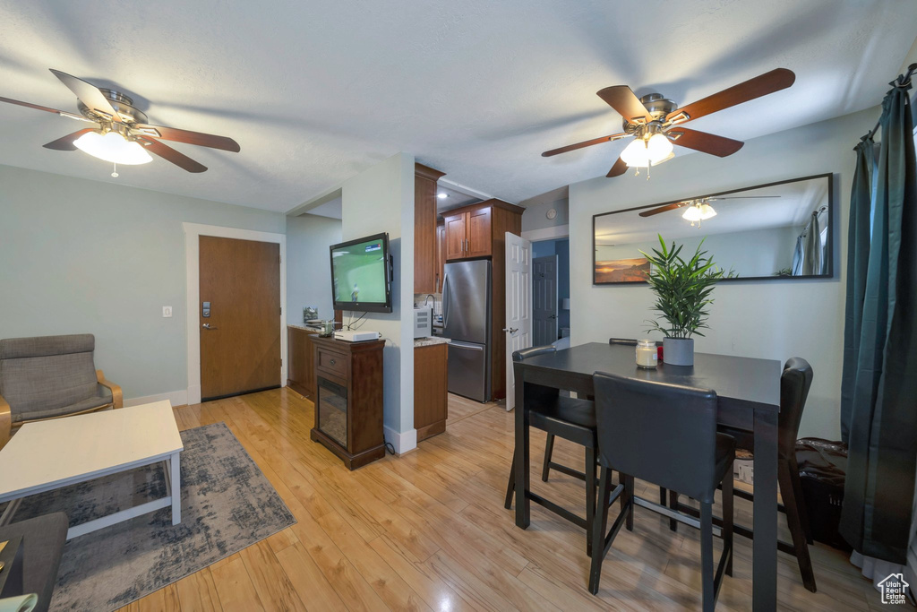 Kitchen featuring freestanding refrigerator, ceiling fan, light wood-style flooring, and baseboards