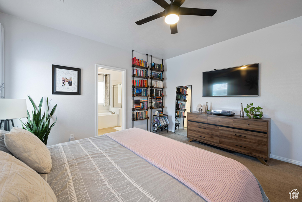 Bedroom with carpet, ensuite bathroom, ceiling fan, and baseboards