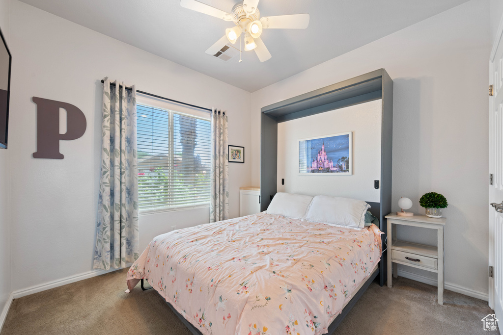 Carpeted bedroom with baseboards and ceiling fan