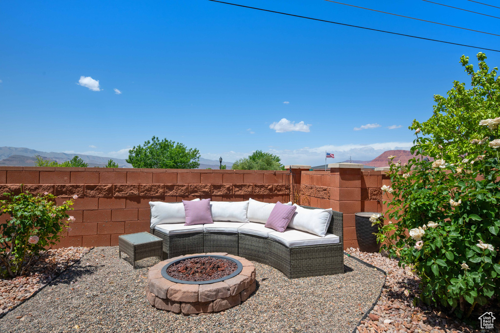 View of patio / terrace featuring a fire pit, fence, and a mountain view