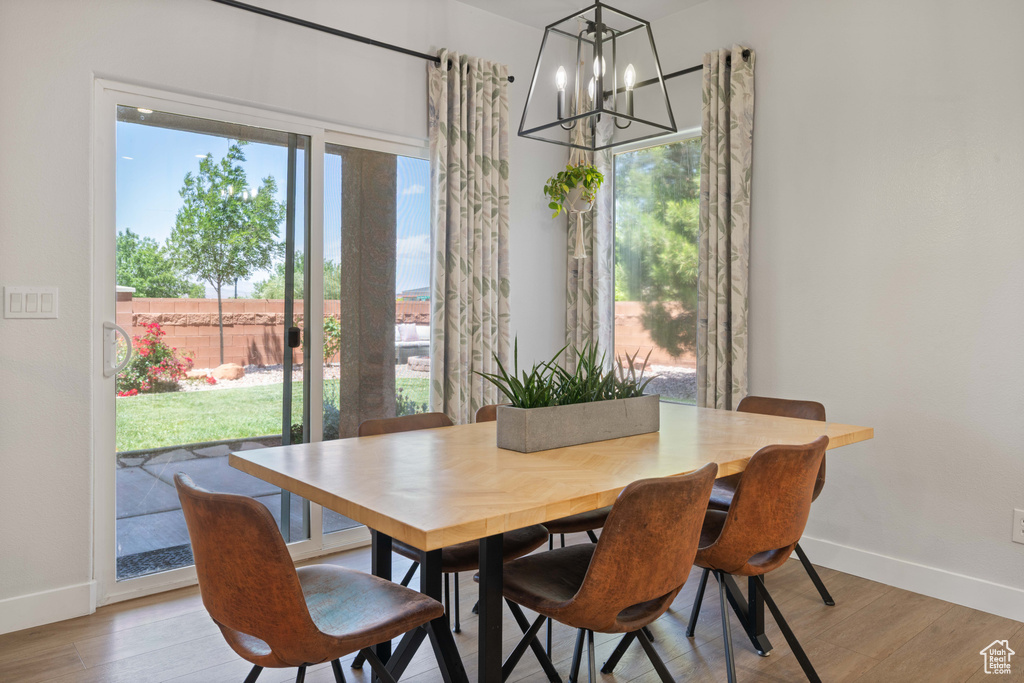 Dining space featuring a chandelier, baseboards, plenty of natural light, and light wood-type flooring
