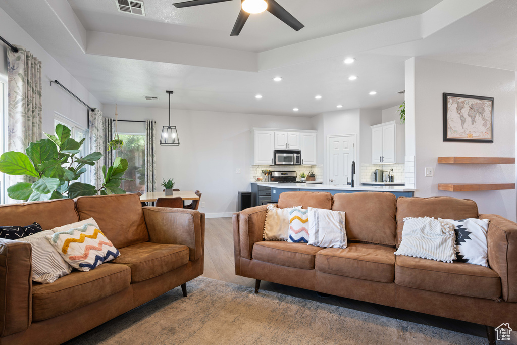 Living room featuring light wood-style floors, recessed lighting, baseboards, and a ceiling fan