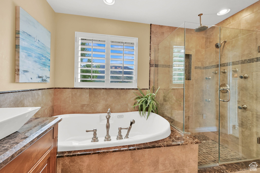 Full bathroom with a shower stall, a bath, and vanity