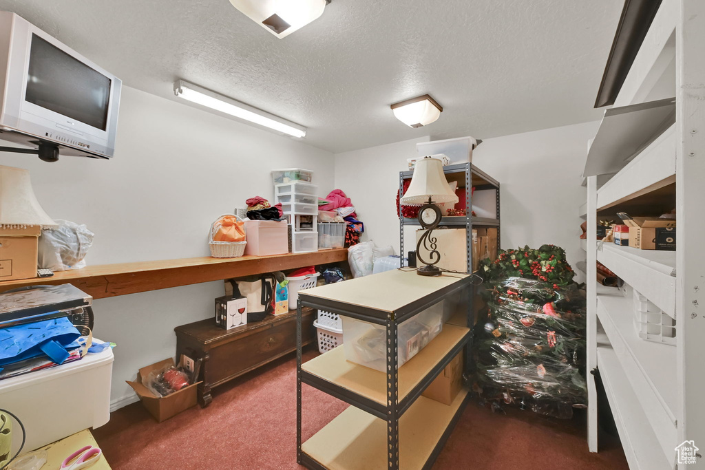 Office area with carpet flooring and a textured ceiling