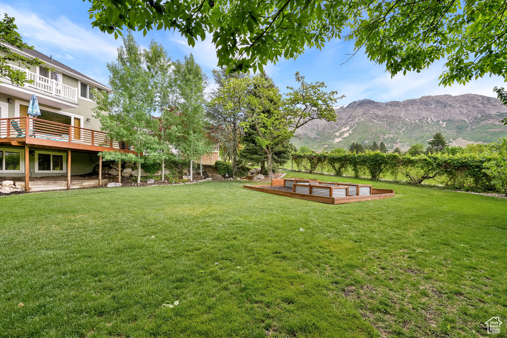 View of yard with a deck with mountain view