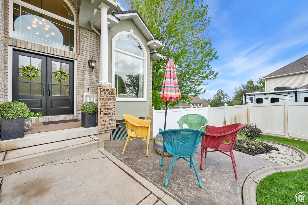 View of patio with french doors, fence, and outdoor dining area