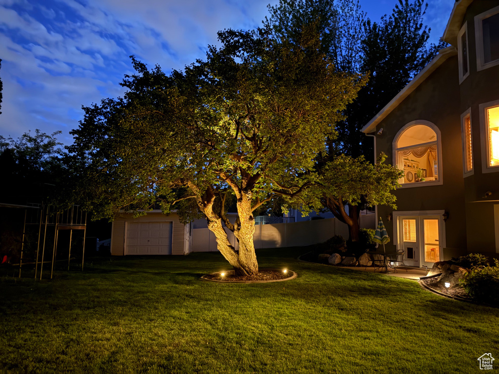 View of grassy yard with a garage