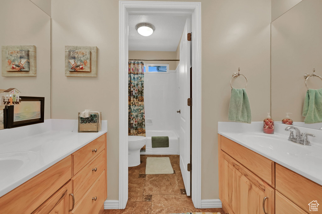 Full bath featuring vanity, toilet, and shower / tub combo with curtain
