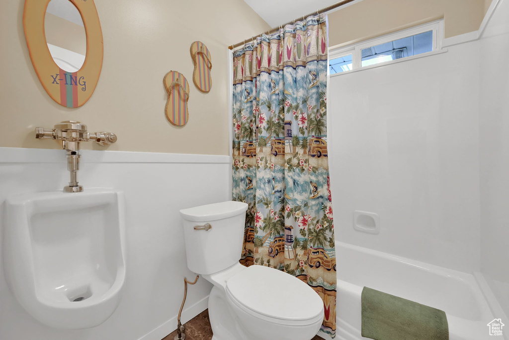 Full bathroom featuring toilet and shower / bath combo with shower curtain