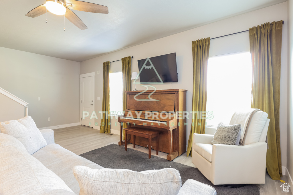Living room with wood finished floors, baseboards, and a ceiling fan