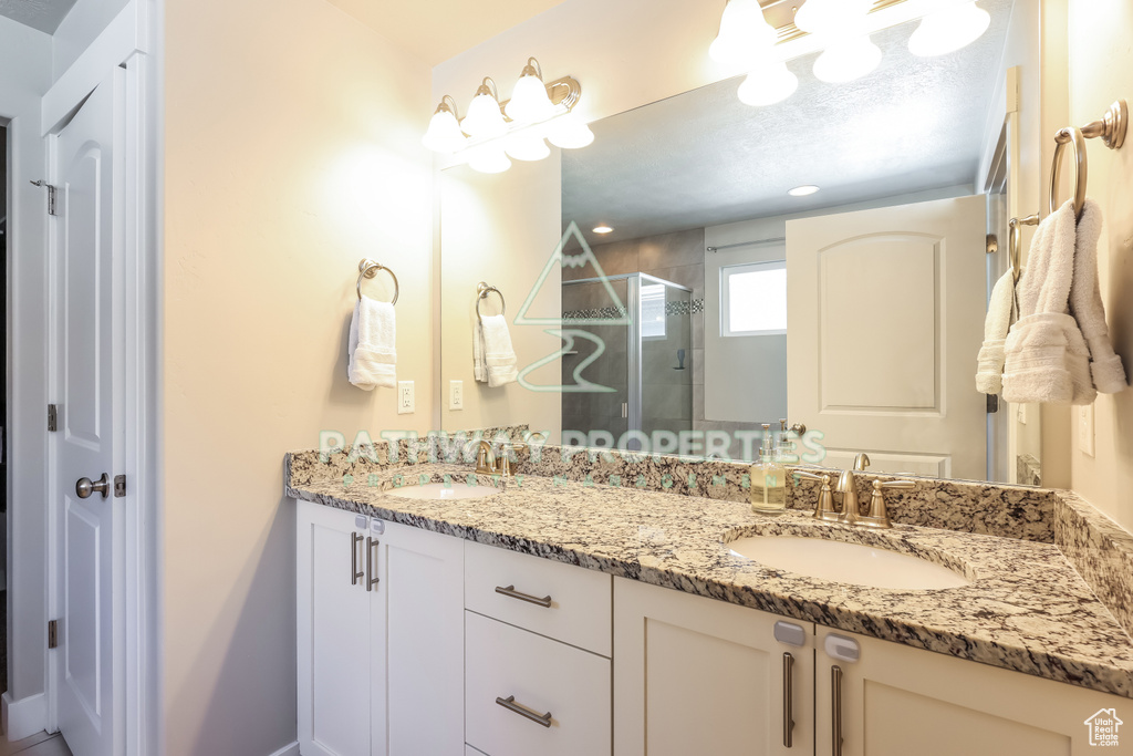Bathroom featuring a shower stall and double vanity