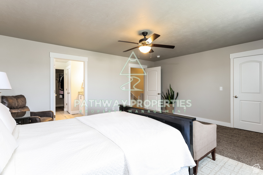 Bedroom with baseboards, ceiling fan, and ensuite bathroom