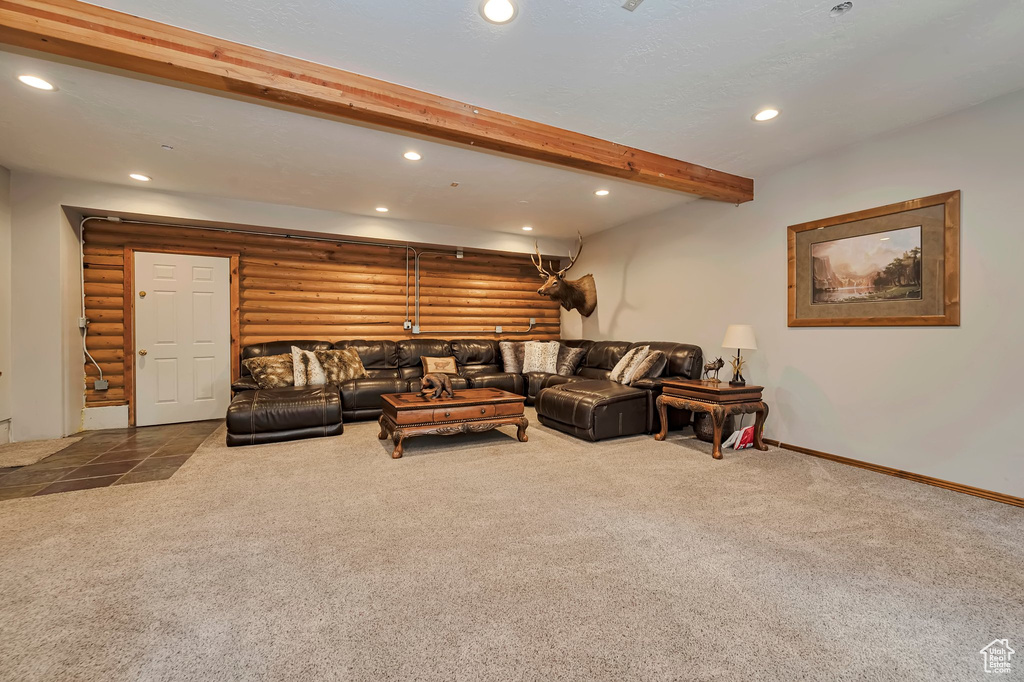 Carpeted living room featuring recessed lighting, log walls, beamed ceiling, and baseboards