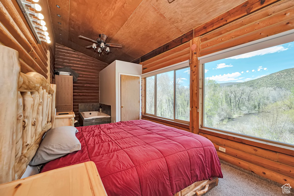 Bedroom with log walls, vaulted ceiling, wood ceiling, and carpet flooring