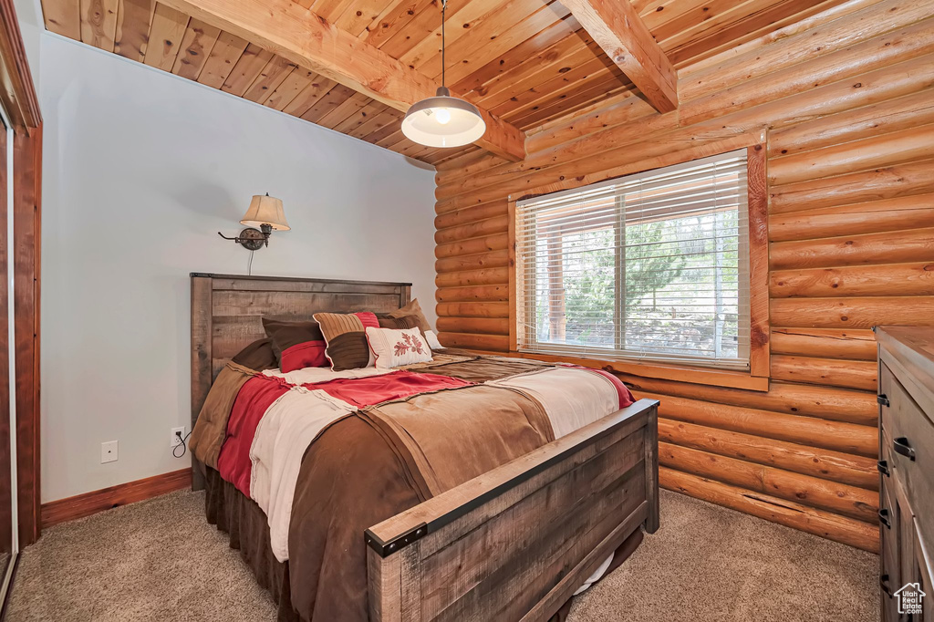 Bedroom with carpet flooring, beamed ceiling, wood ceiling, baseboards, and log walls