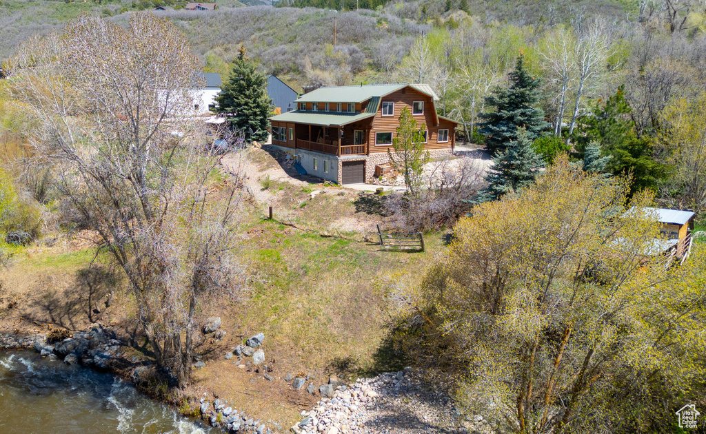 Aerial view of property and surrounding area with a heavily wooded area