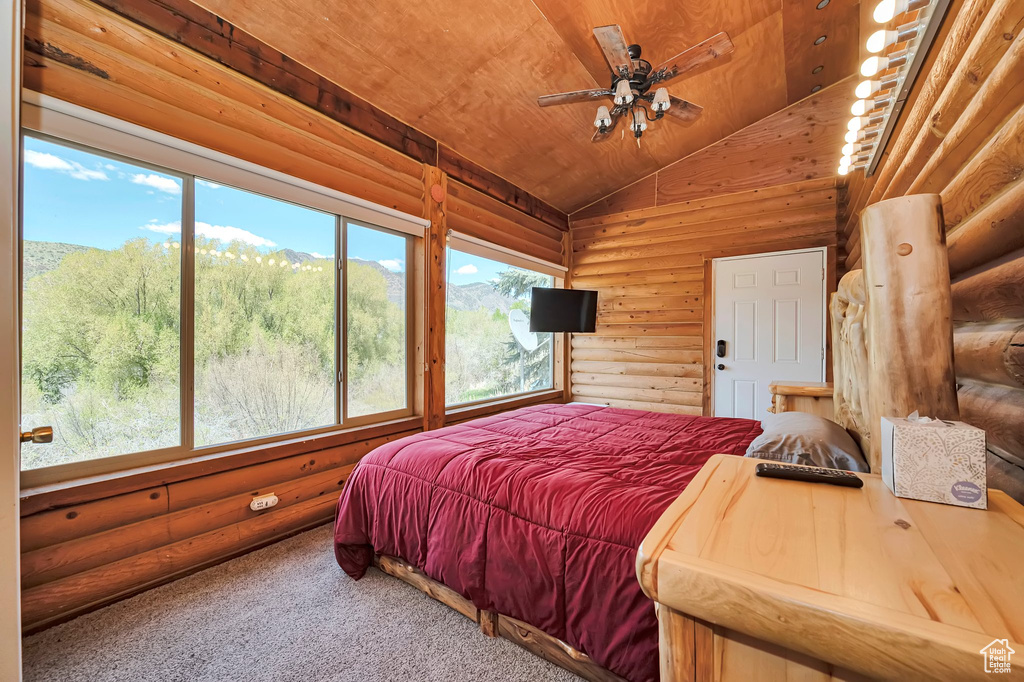 Carpeted bedroom with rustic walls, lofted ceiling, and wooden ceiling