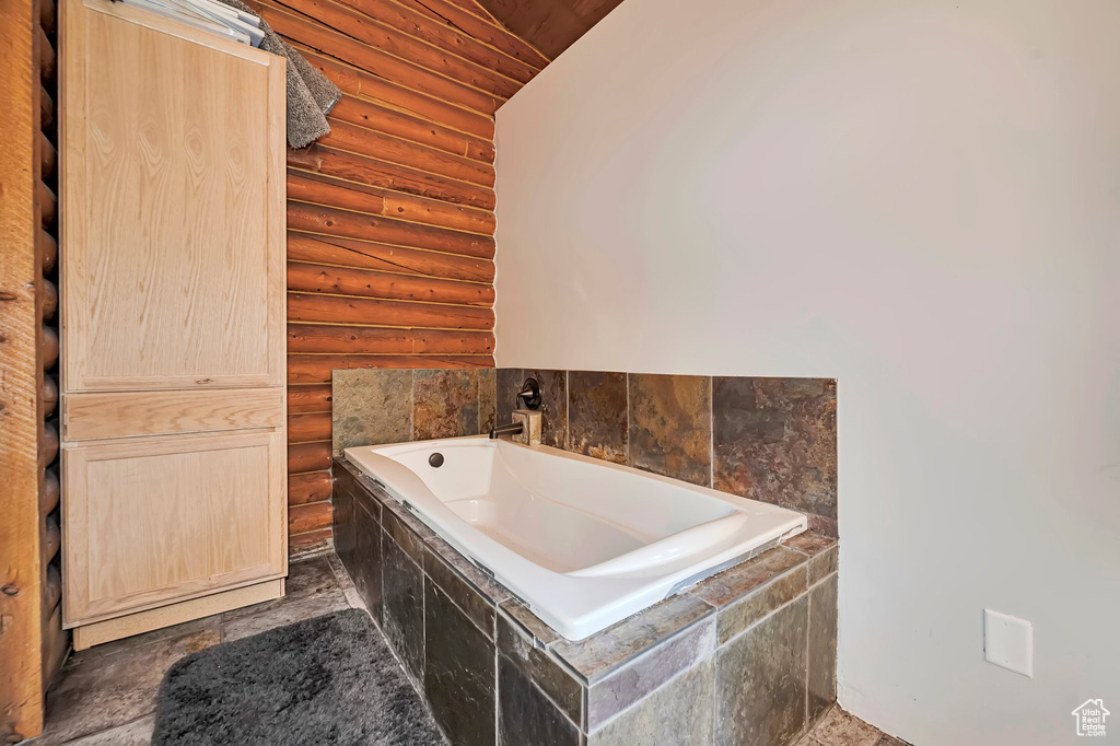 Bathroom with log walls and a bath