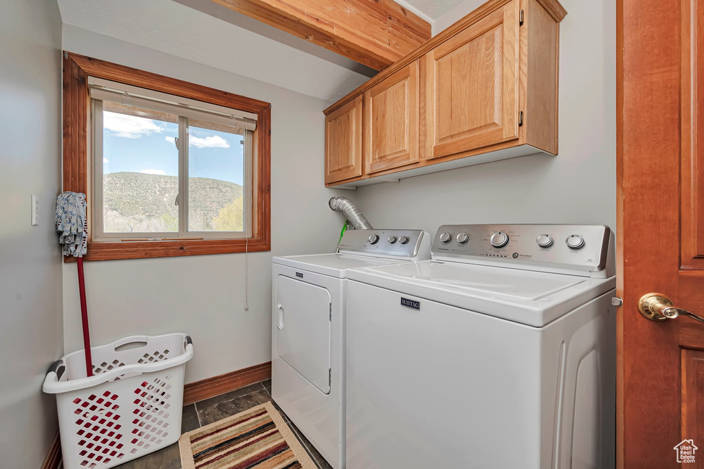 Washroom with cabinet space, independent washer and dryer, and baseboards
