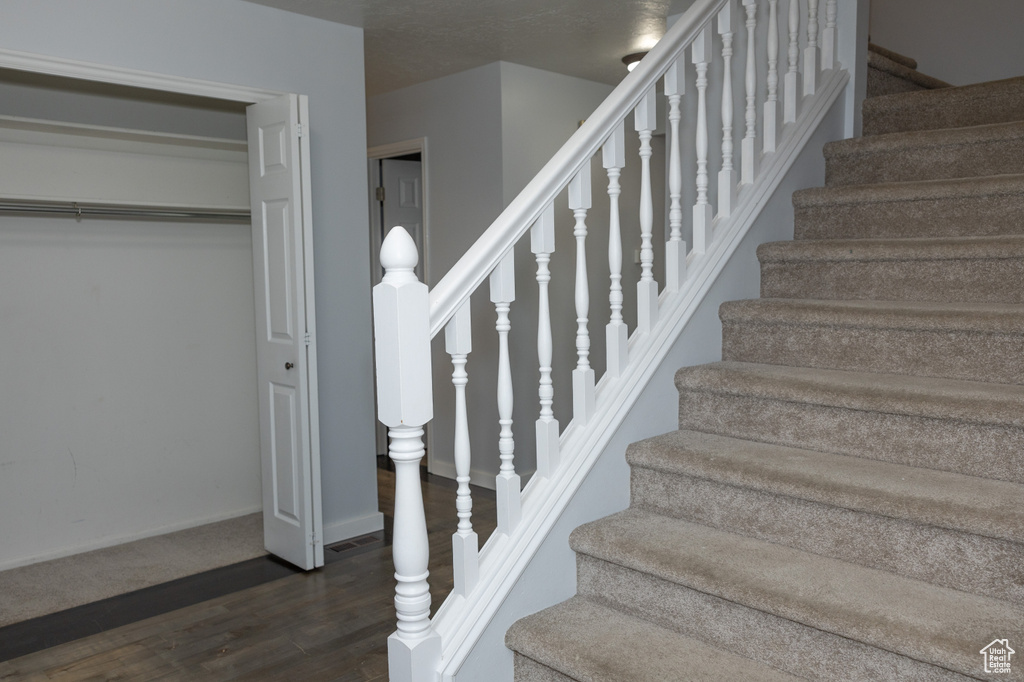 Staircase featuring wood finished floors and baseboards