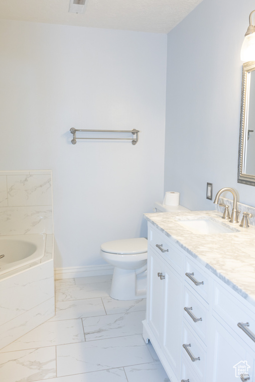 Full bathroom with marble finish floors, toilet, vanity, a garden tub, and baseboards