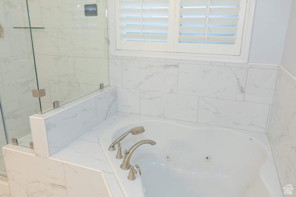 Bathroom featuring a jetted tub and a shower