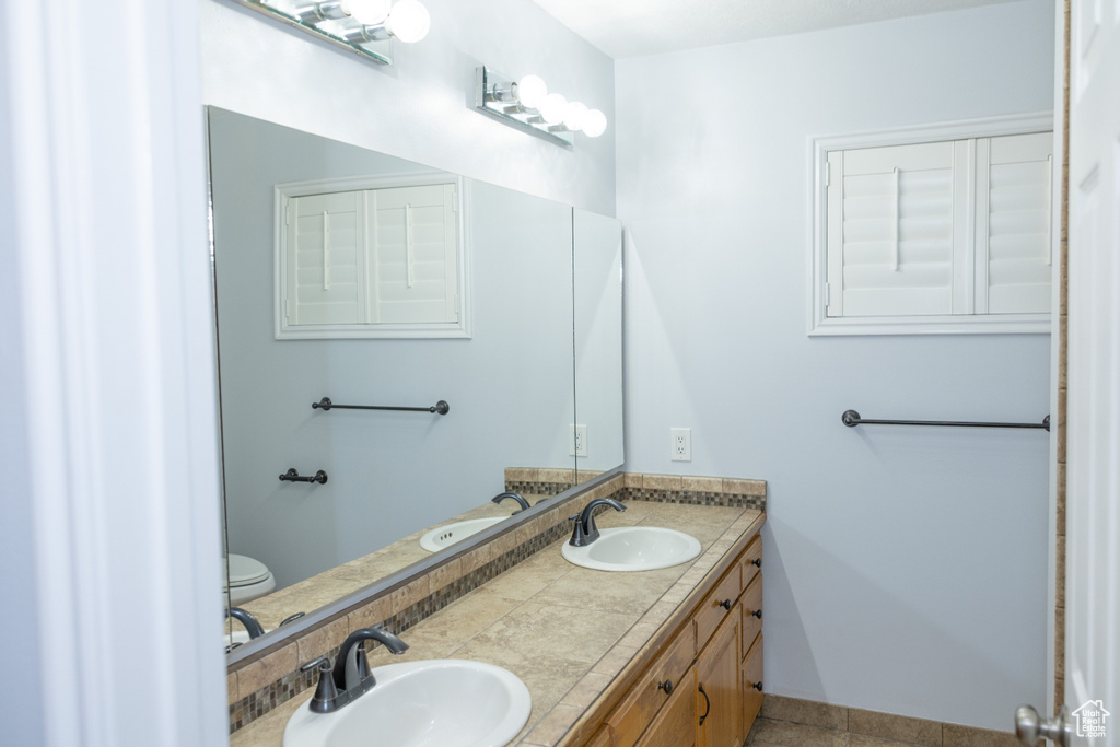 Full bathroom featuring double vanity and tile patterned flooring