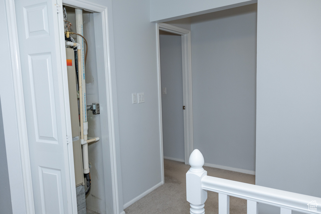 Hallway featuring carpet and baseboards