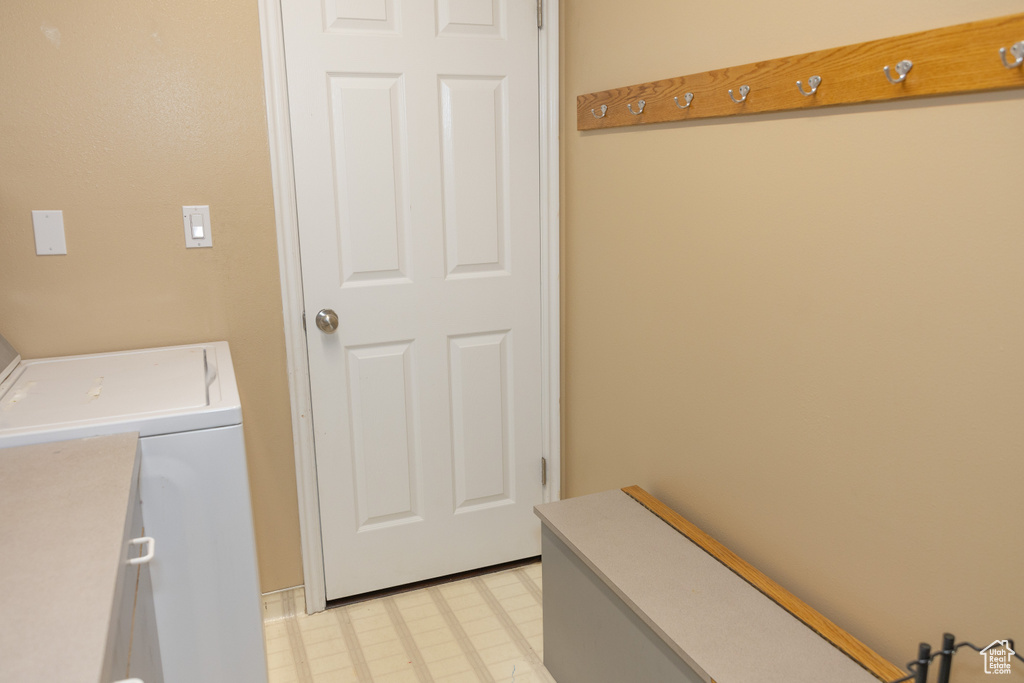 Clothes washing area featuring light flooring and washing machine and clothes dryer