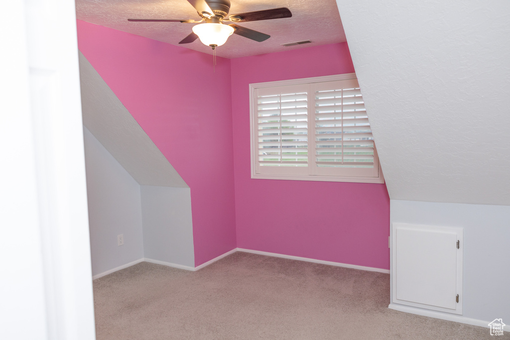 Additional living space featuring a textured ceiling, ceiling fan, carpet, and baseboards
