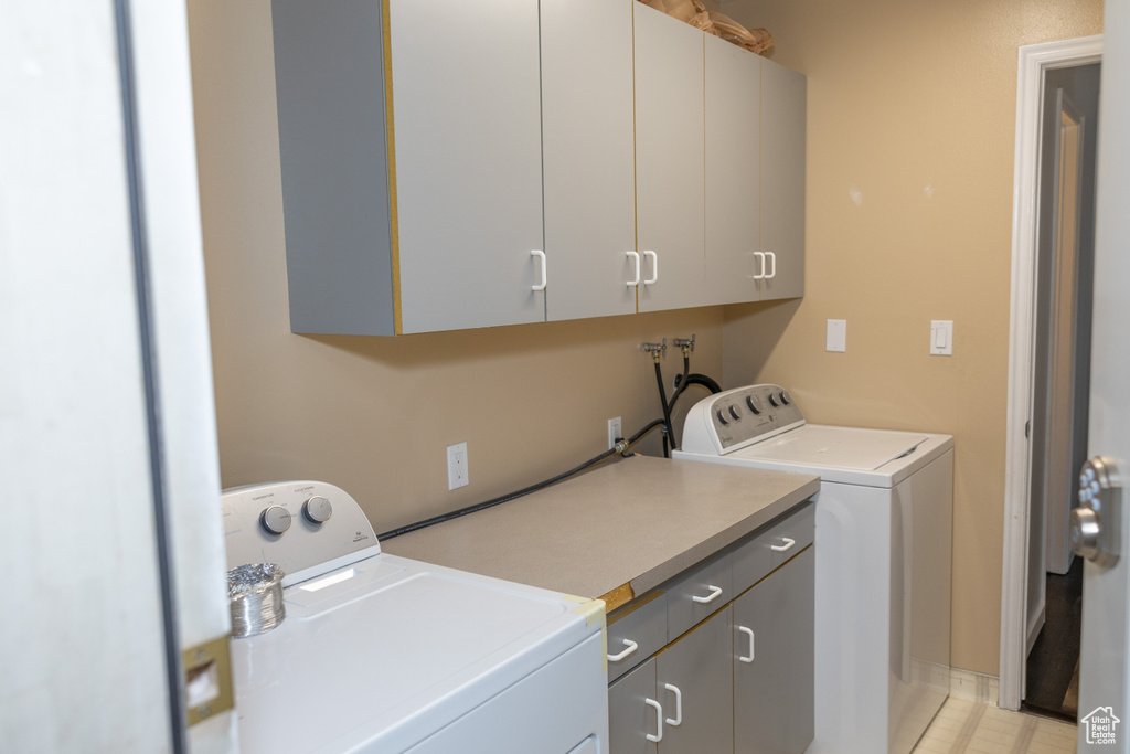 Laundry room with cabinet space, washing machine and clothes dryer, and baseboards