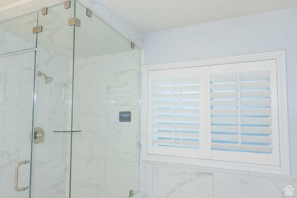 Bathroom featuring a marble finish shower
