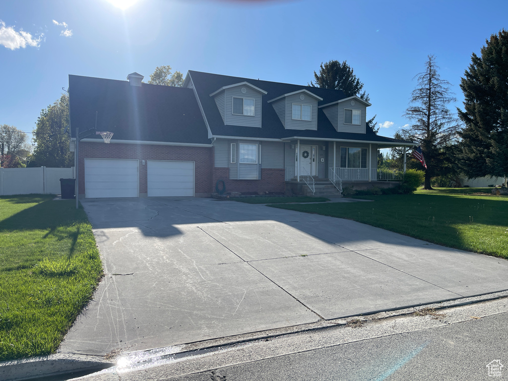 View of front of home with brick siding, a garage, a porch, and concrete driveway