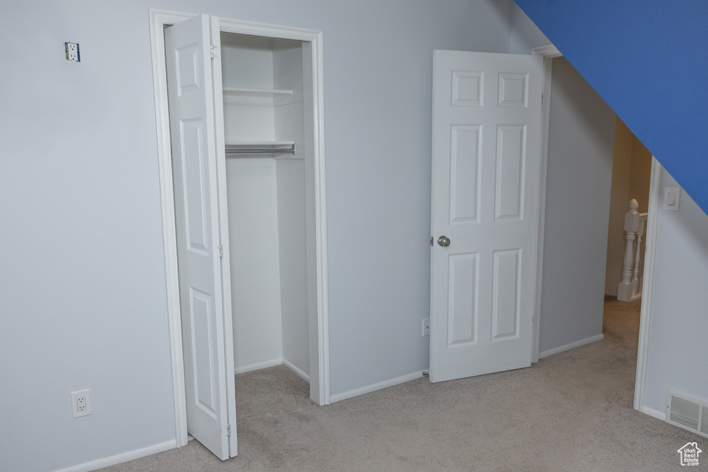 Unfurnished bedroom with carpet flooring, a closet, and baseboards