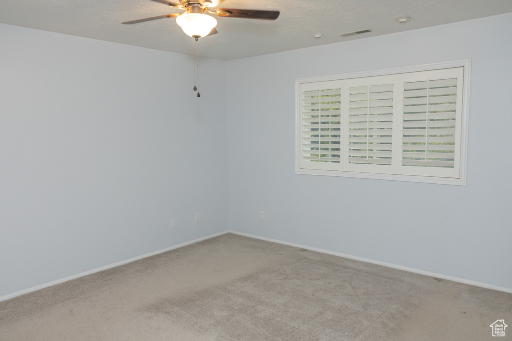 Unfurnished room featuring carpet floors, a ceiling fan, and baseboards