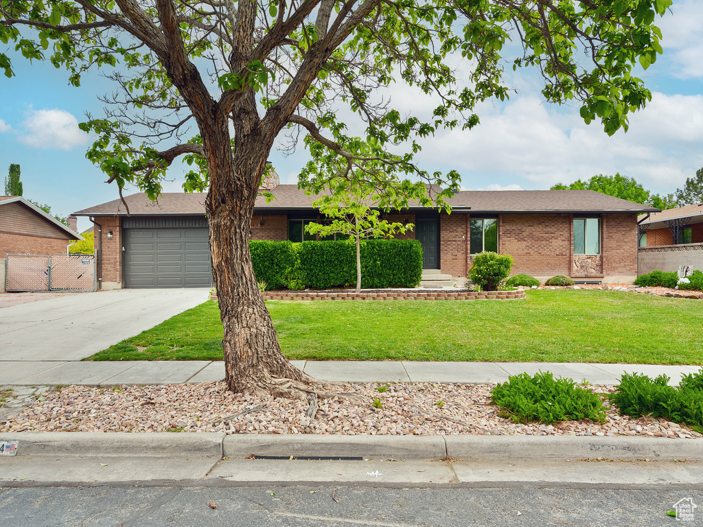 View of front of home with brick siding, concrete driveway, and an attached garage