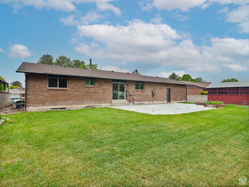 Rear view of property featuring a patio area, entry steps, and brick siding