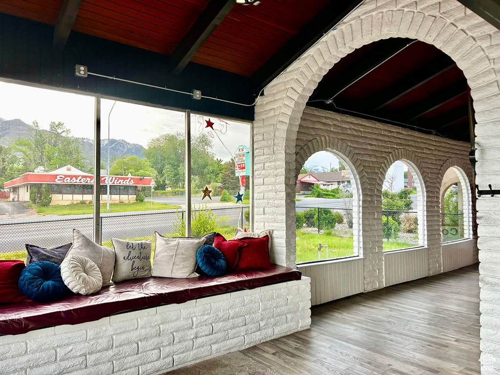 Sunroom featuring beamed ceiling and a mountain view