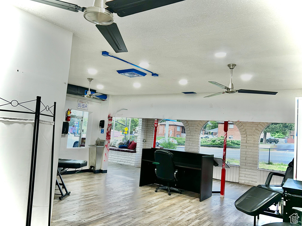 Workout area with ceiling fan, wood finished floors, a textured ceiling, and recessed lighting