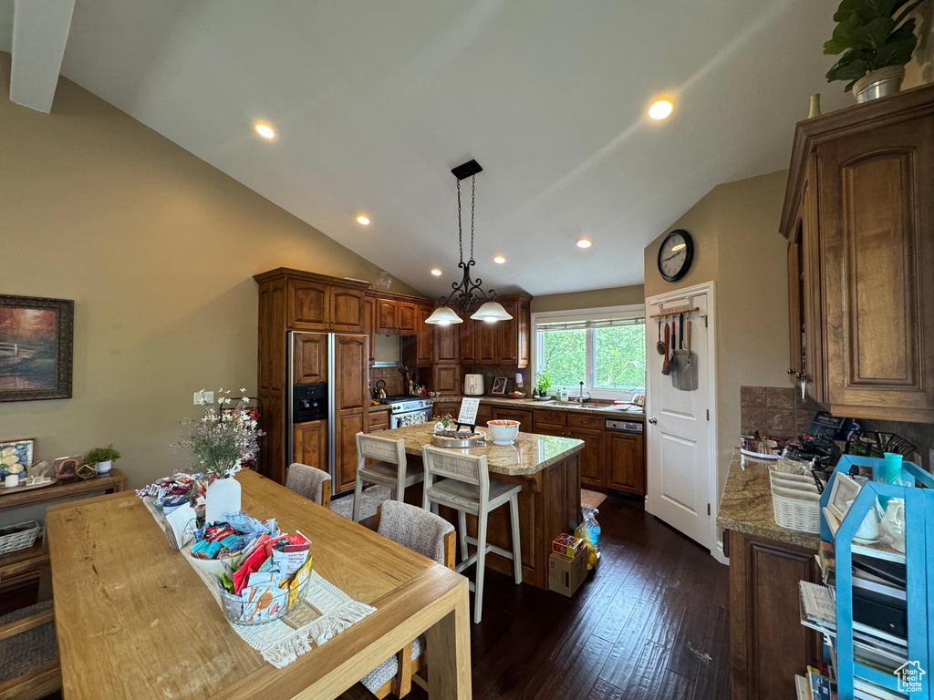 Kitchen with paneled fridge, a sink, a center island, tasteful backsplash, and dark wood-style flooring