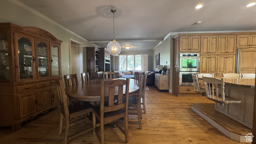 Dining space featuring crown molding, light wood-style floors, and recessed lighting