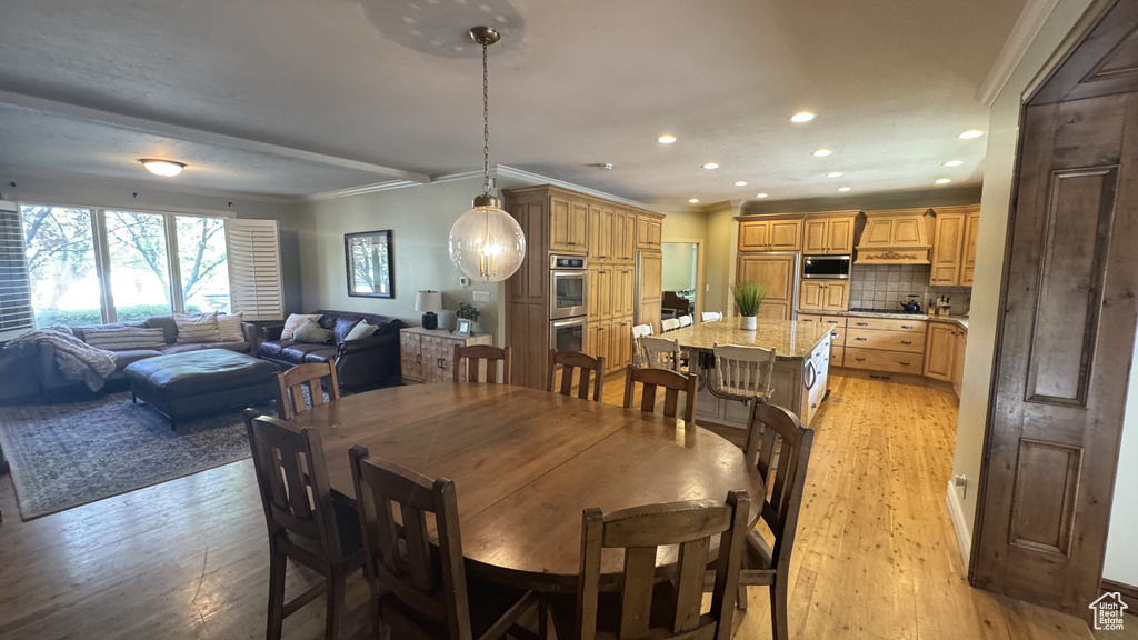 Dining space featuring light wood-type flooring, recessed lighting, and ornamental molding