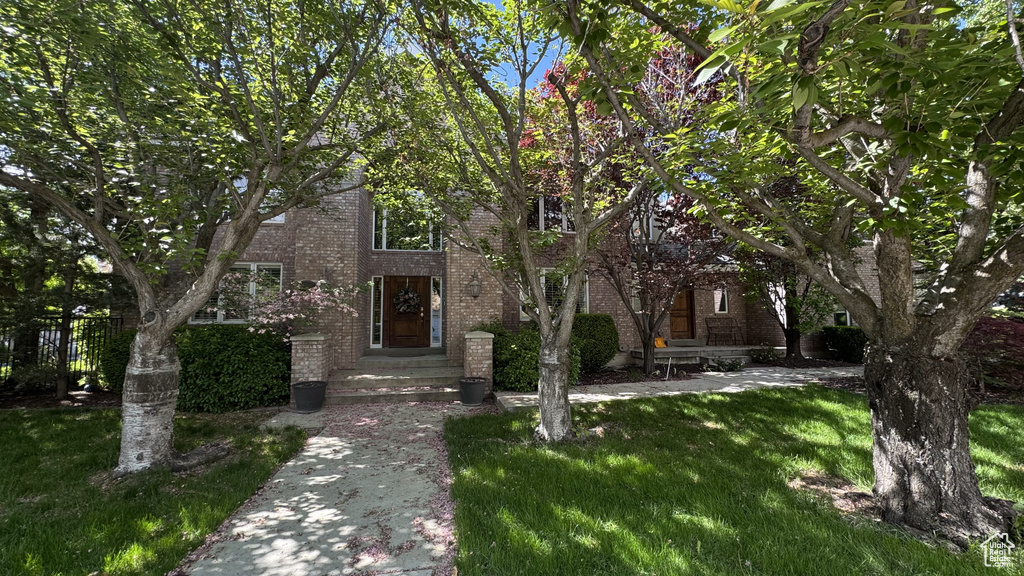 View of front facade with brick siding and a front yard