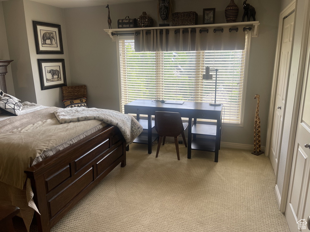 Bedroom featuring light carpet and baseboards