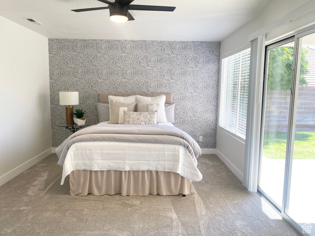 Bedroom with wallpapered walls, access to exterior, baseboards, carpet flooring, and ceiling fan