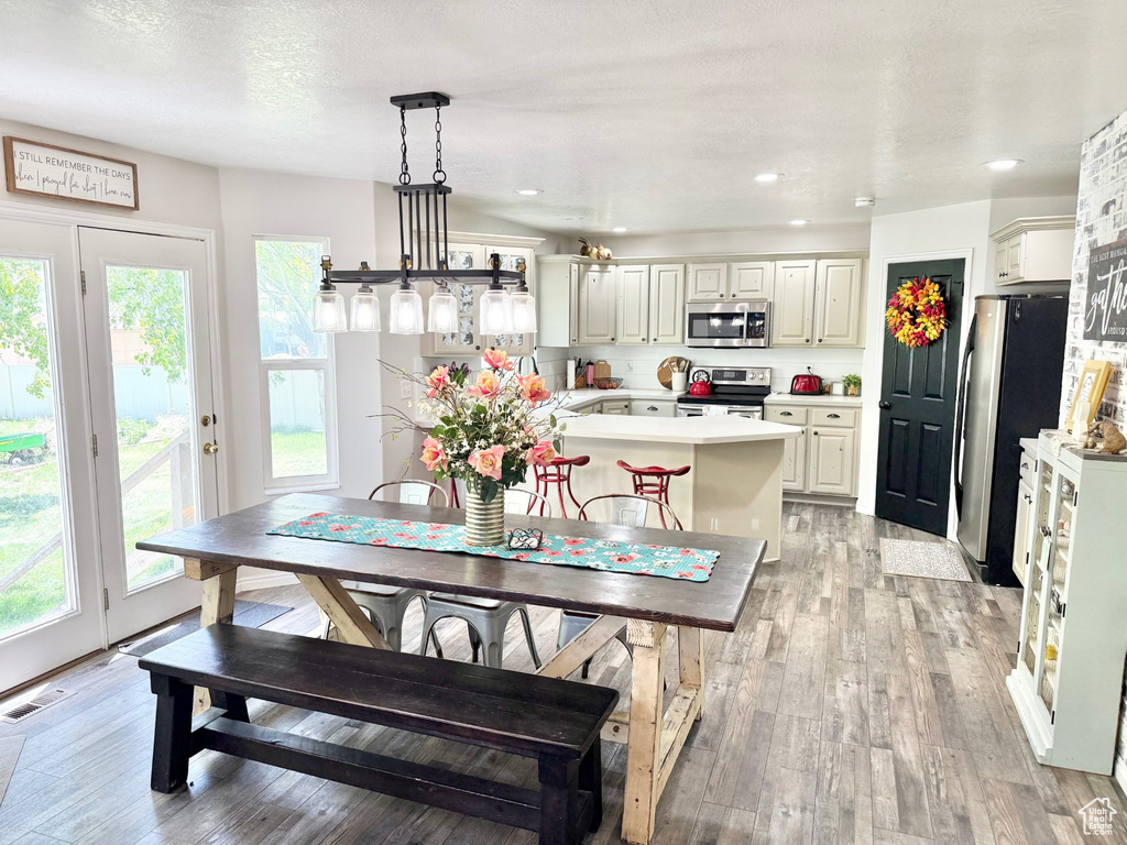 Dining space with light wood finished floors and recessed lighting