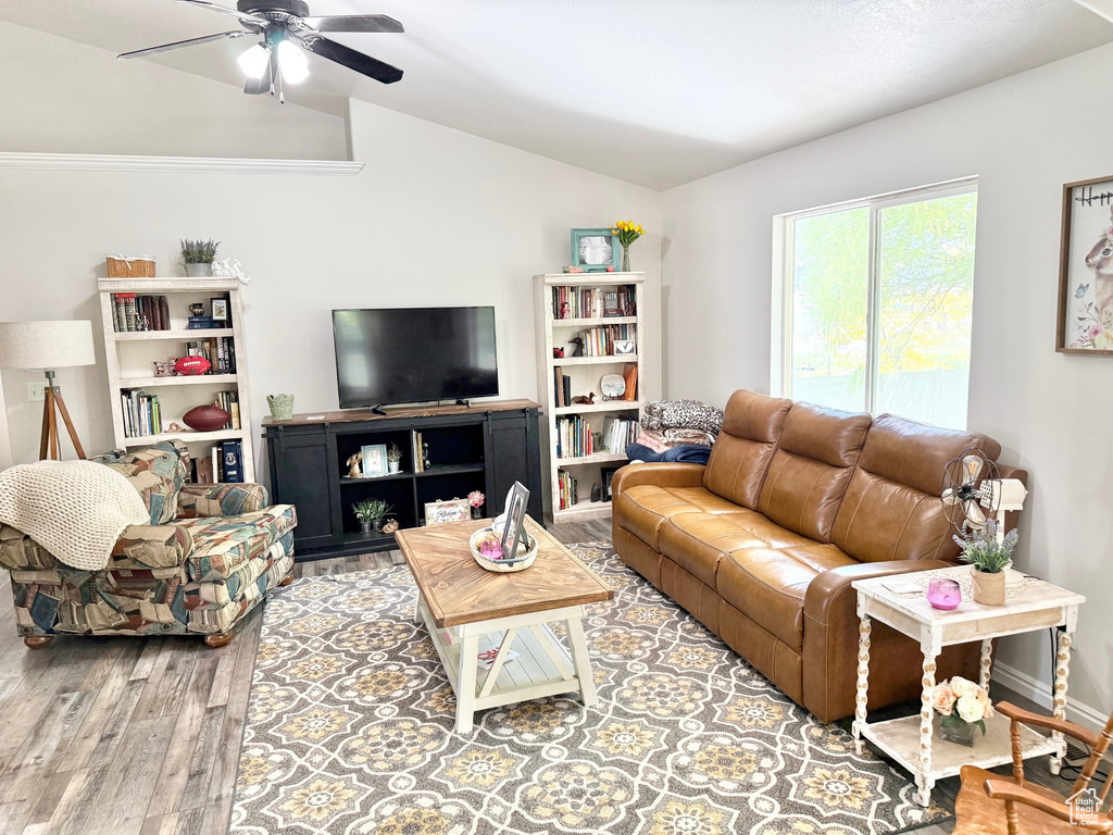 Living room with vaulted ceiling, wood finished floors, and a ceiling fan